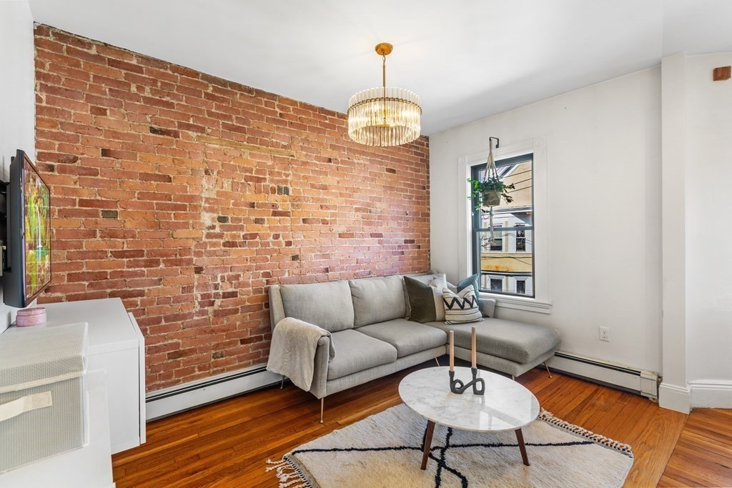 217 Boylston Street, Unit 3 Boston, MA 02130 - Photo 9 of 18 a living room with fireplace furniture and a chandelier