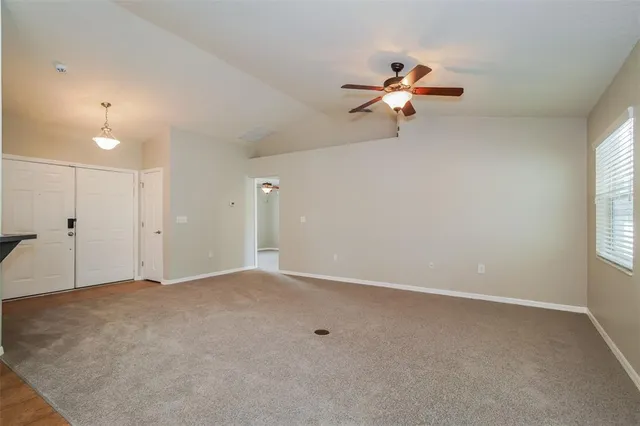 an empty room with windows and fan