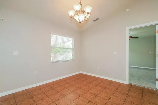 a view of a bedroom with wooden floor and chandelier