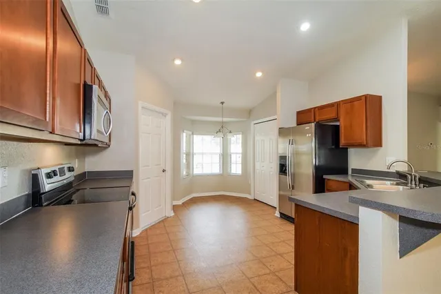 a kitchen with stainless steel appliances granite countertop a refrigerator and a stove top oven