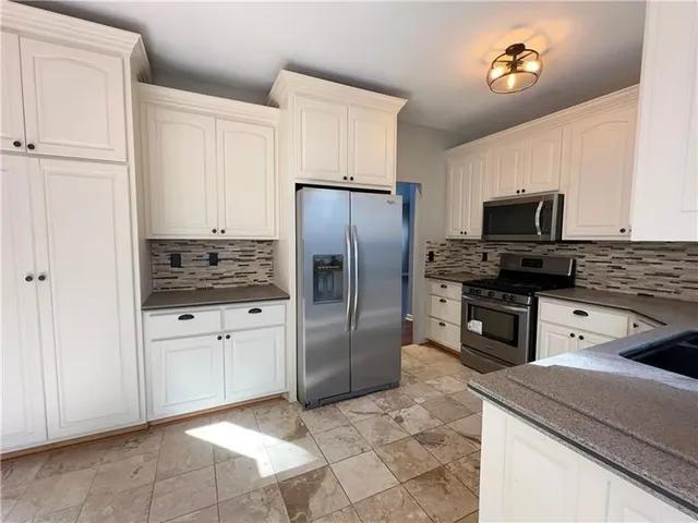 a kitchen with stainless steel appliances granite countertop a sink stove and cabinets