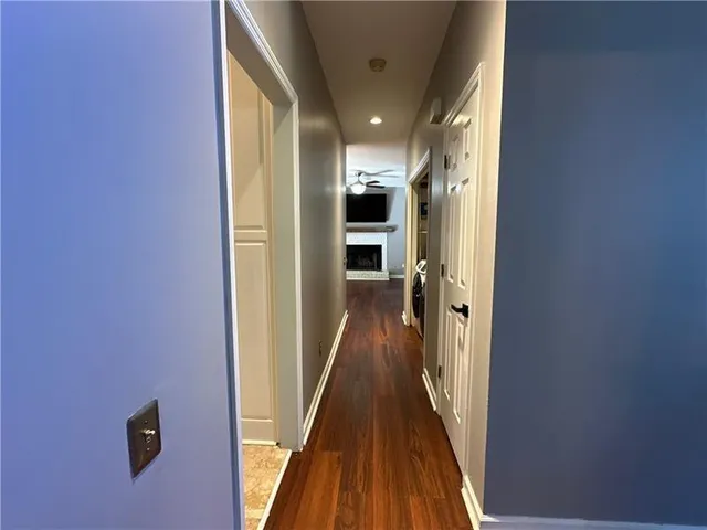 a view of an empty room with wooden floor a fireplace and a window
