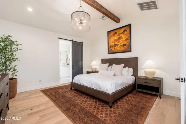 a bedroom with a bed and a potted plant on dresser