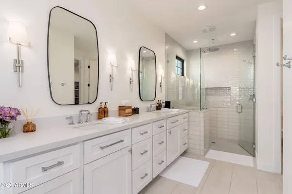 a bathroom with double vanity sinks and a mirror
