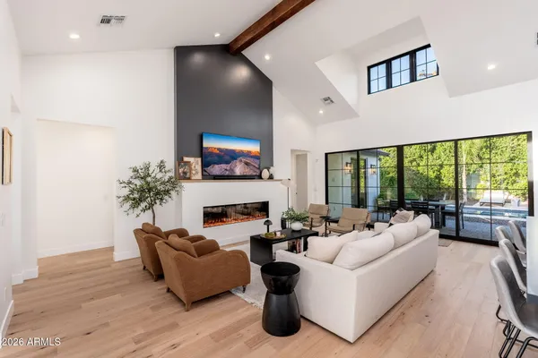 a living room with fireplace furniture and a large window