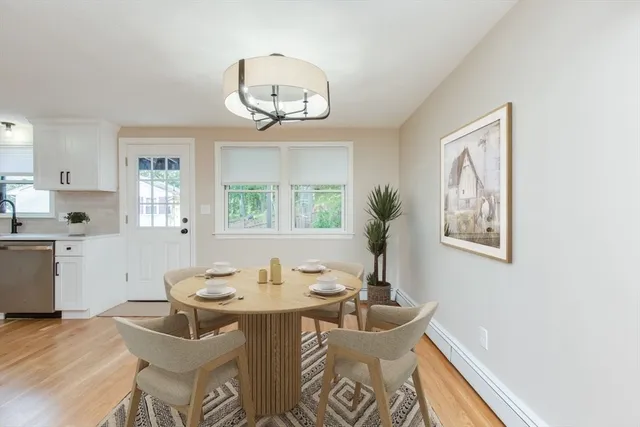 a view of a dining room with furniture a chandelier and wooden floor