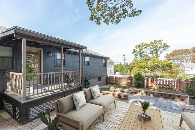 a view of a backyard with plants and large tree