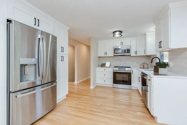 a kitchen with stainless steel appliances granite countertop a refrigerator and a stove top oven