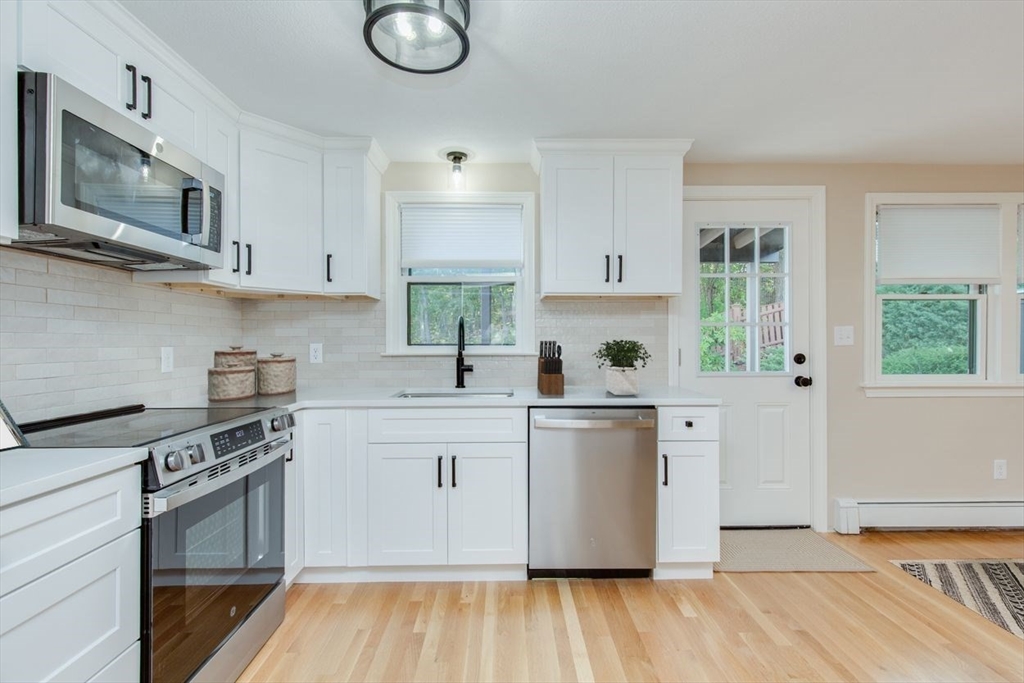 2 Oceanview Avenue Saugus, MA 01906 - Photo 6 of 41 a kitchen with stainless steel appliances granite countertop a stove a sink dishwasher and white cabinets with wooden floor