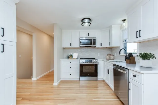 a kitchen with kitchen island granite countertop a sink cabinets and stainless steel appliances
