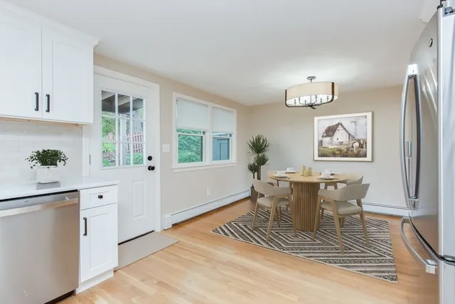 a dining room with wooden floor and window