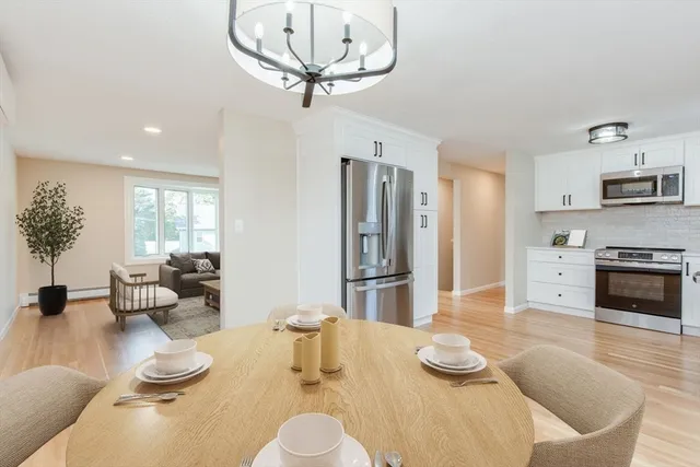 a kitchen with stainless steel appliances kitchen island granite countertop a table and chairs in it