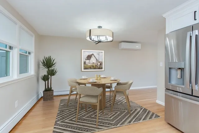 a dining room with wooden floor a chandelier a wooden table and chairs