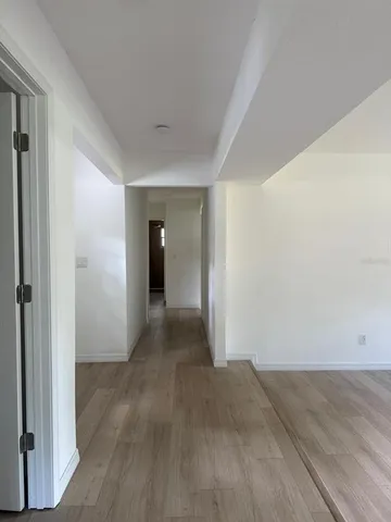 a view of a big room with wooden floor and windows
