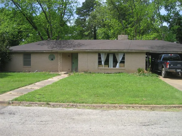 a front view of a house with a garden and yard