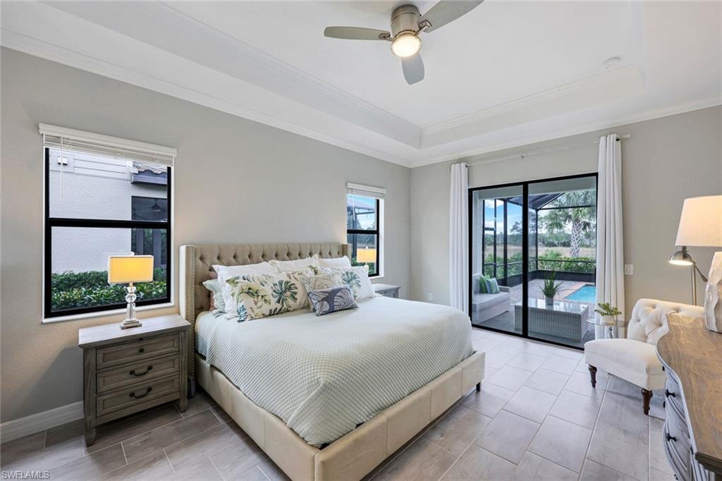 19437 The Pl Boulevard Estero, FL 33928 - Photo 13 of 37 a bedroom with a large bed and a flat tv screen on dresser