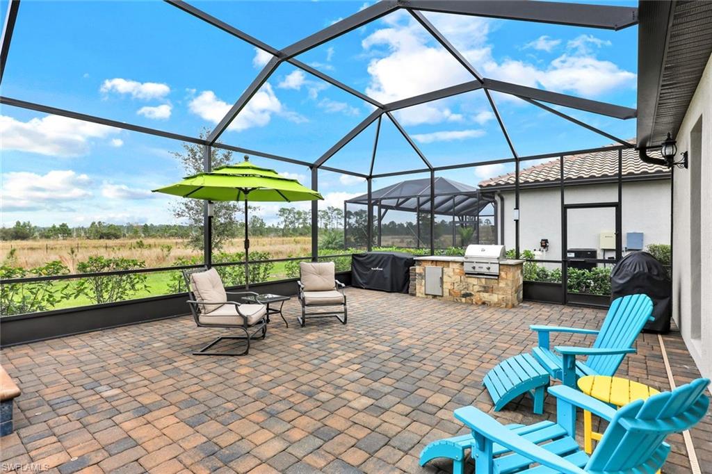 19437 The Pl Boulevard Estero, FL 33928 - Photo 26 of 37 a view of a patio with a table and chairs under an umbrella