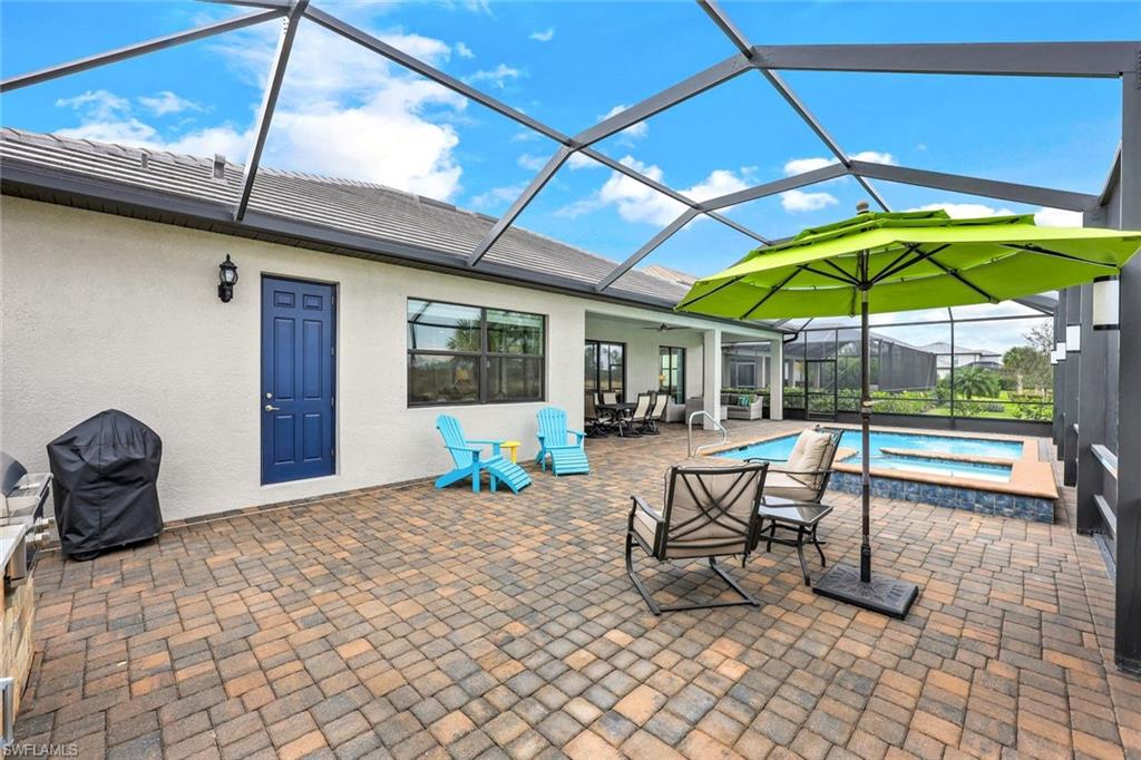 19437 The Pl Boulevard Estero, FL 33928 - Photo 27 of 37 a view of a patio with a table and chairs under an umbrella