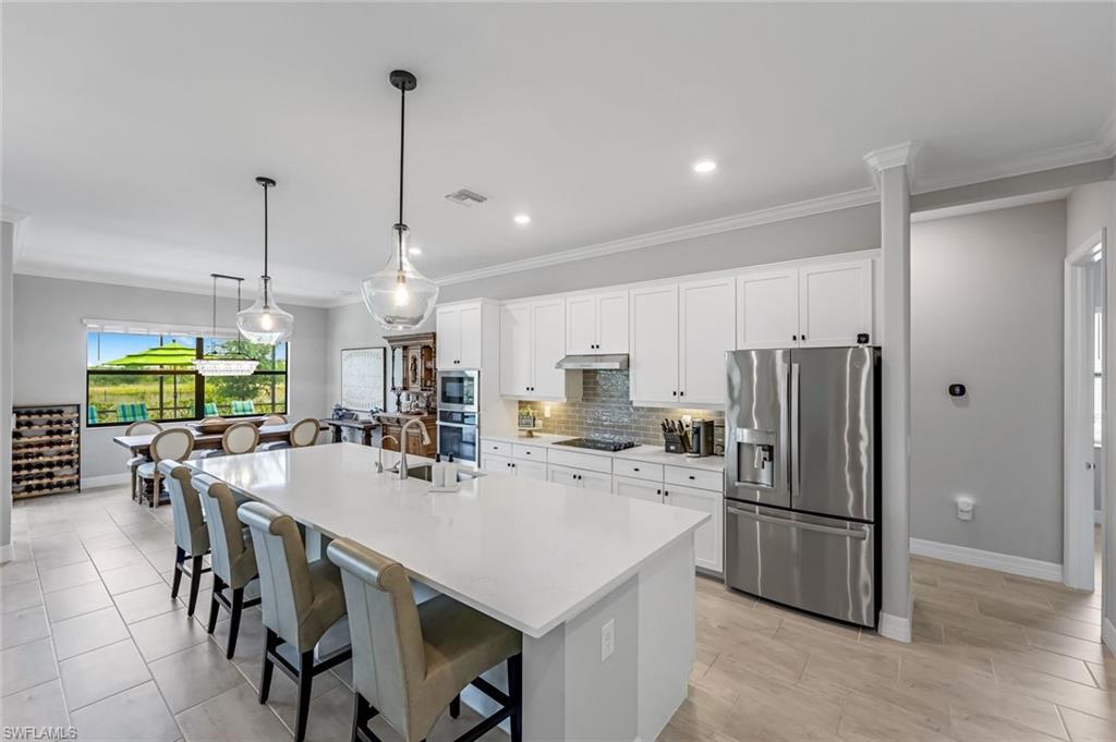 19437 The Pl Boulevard Estero, FL 33928 - Photo 4 of 37 a kitchen with refrigerator and chairs