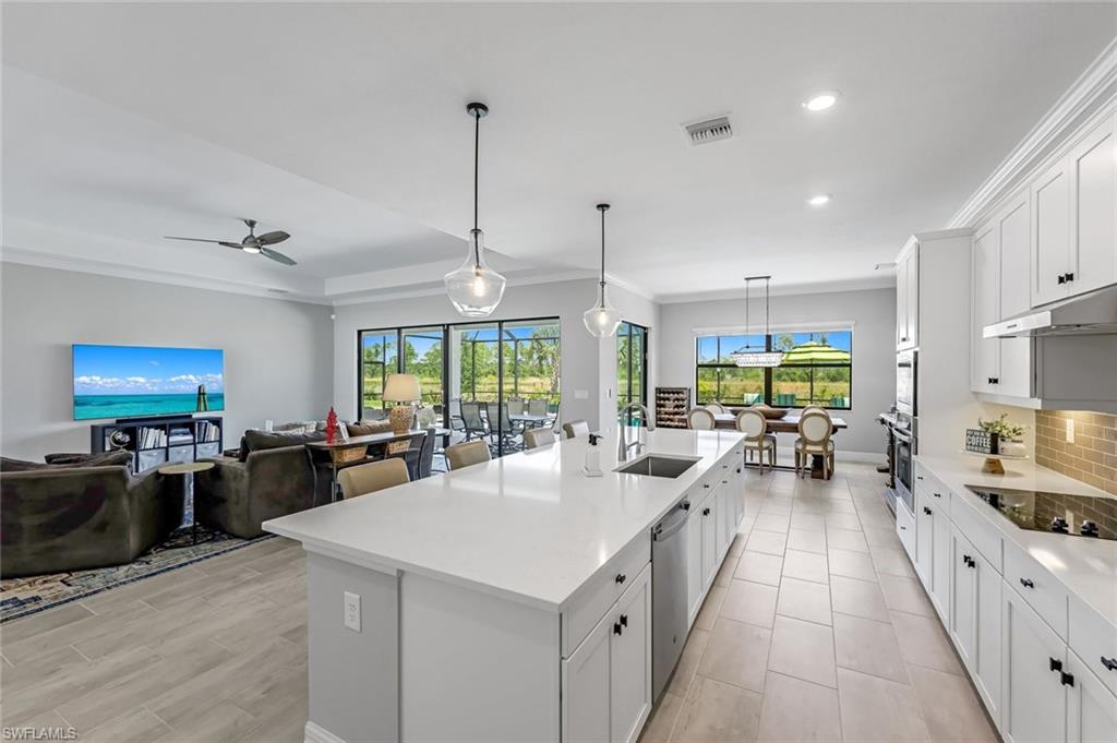 19437 The Pl Boulevard Estero, FL 33928 - Photo 6 of 37 a large kitchen with kitchen island a large window a sink a counter space and stainless steel appliances