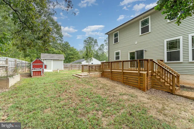 a view of house with backyard and deck