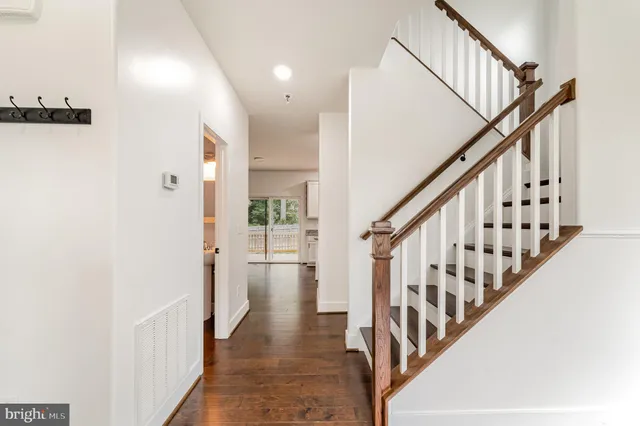 a view of a hallway with wooden floor and staircase
