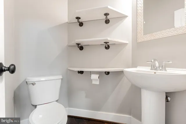 a bathroom with a sink a toilet and a mirror