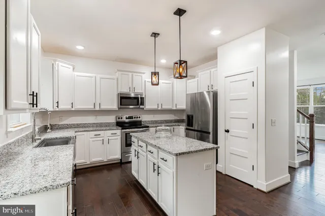 a kitchen with stainless steel appliances granite countertop a stove refrigerator sink and cabinets