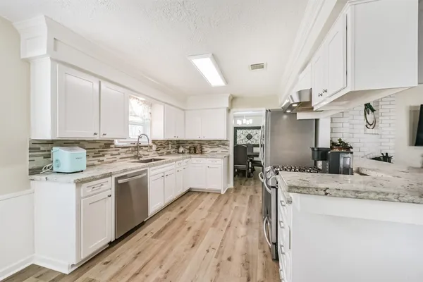 a kitchen with a sink a counter top space cabinets and stainless steel appliances