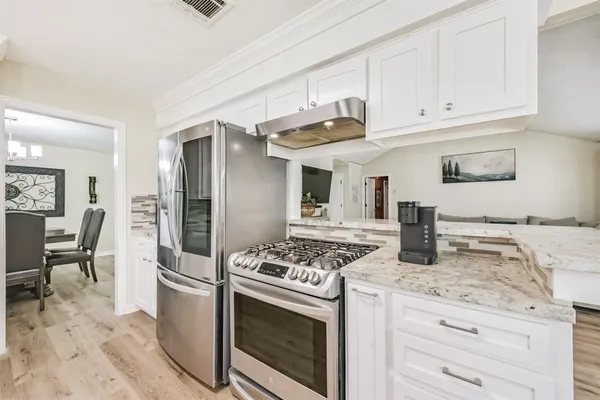a kitchen with granite countertop a sink stove and refrigerator