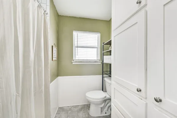 a spacious bedroom with a bed and a chandelier