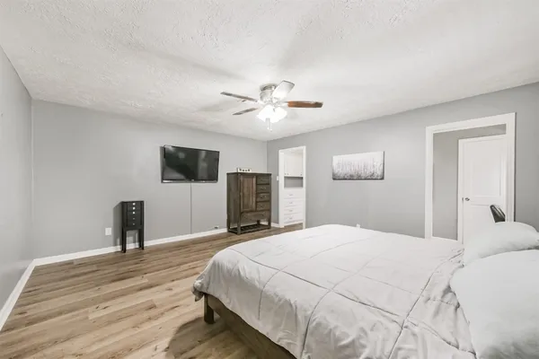 a bedroom with a large bed and a ceiling fan