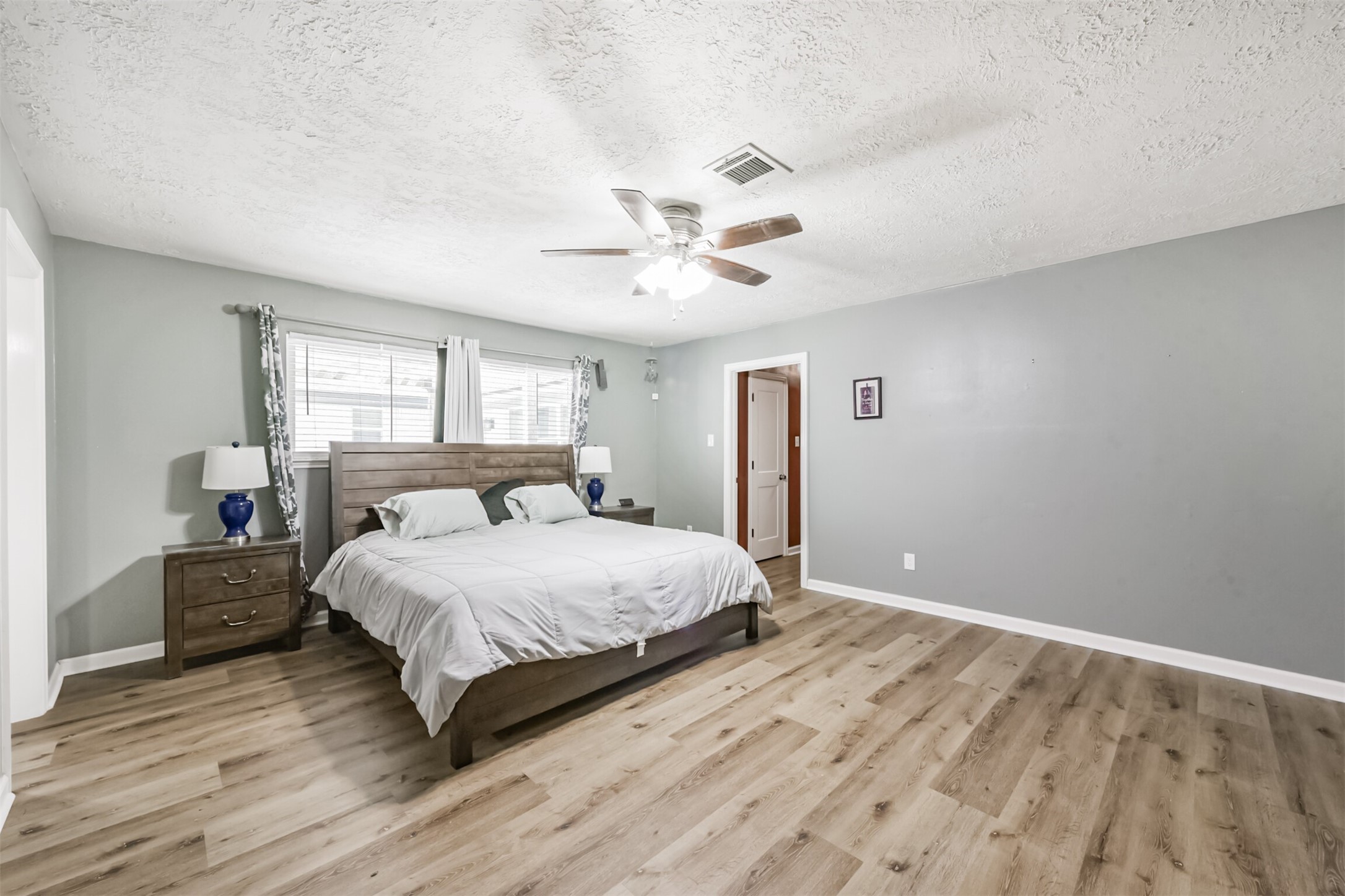 2011 North Palm Court Pasadena, TX 77502 - Photo 29 of 39 a bedroom with a large bed and a ceiling fan