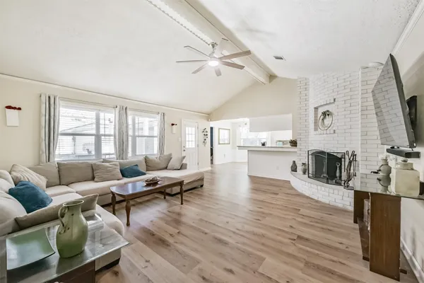 a living room with furniture flat screen tv and wooden floor