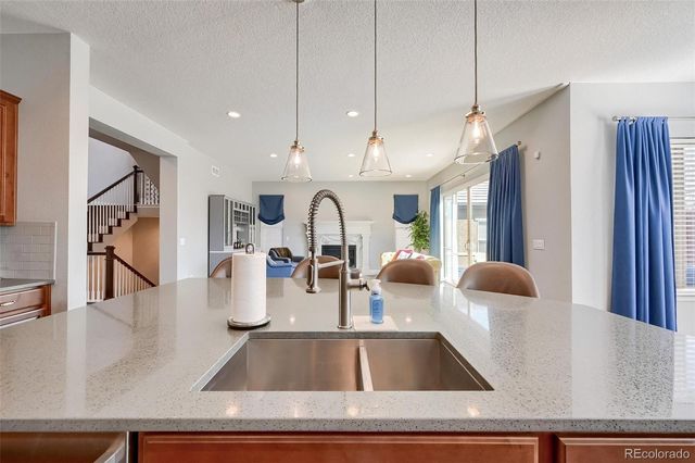 a room with lots of white furniture and chandelier
