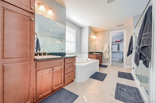 a large bathroom with a glass door shower a sink and a mirror