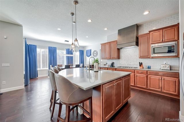 a kitchen with granite countertop a sink stove and wooden floor