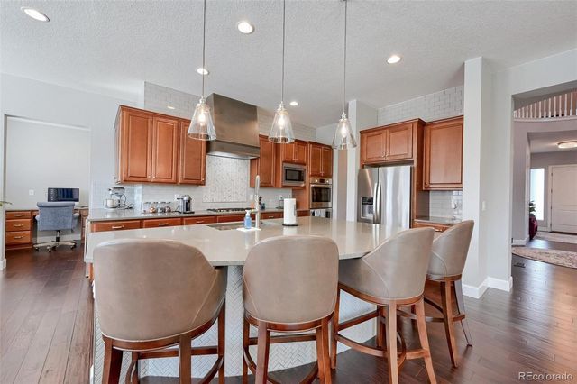 a kitchen with granite countertop white cabinets and chairs