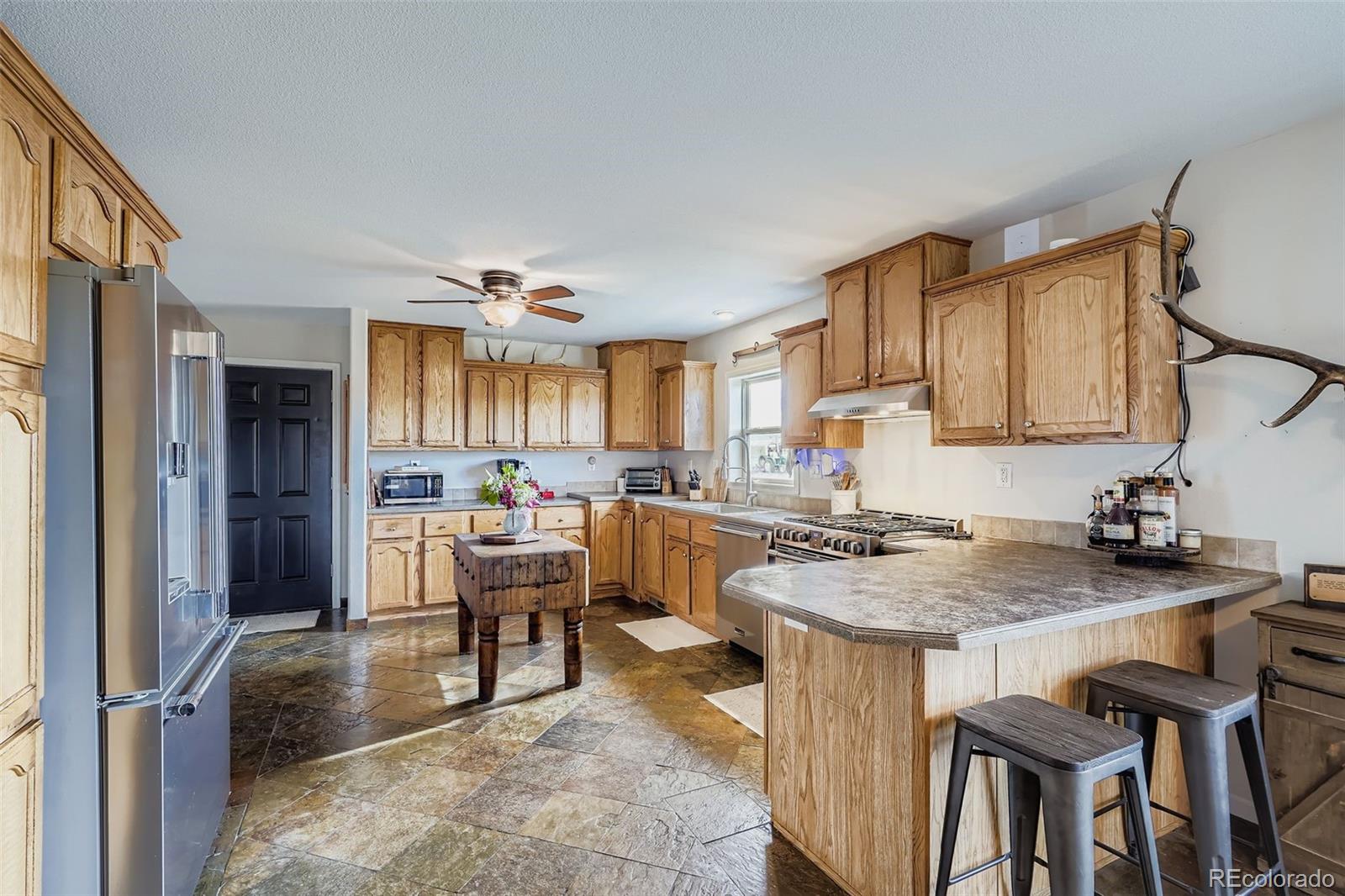 26540 Flower Circle Simla, CO 80835 - Photo 15 of 40 a kitchen with a table chairs refrigerator and cabinets