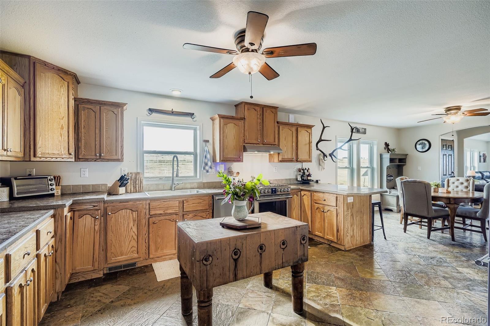 26540 Flower Circle Simla, CO 80835 - Photo 17 of 40 a kitchen with stainless steel appliances granite countertop a dining table chairs refrigerator and sink