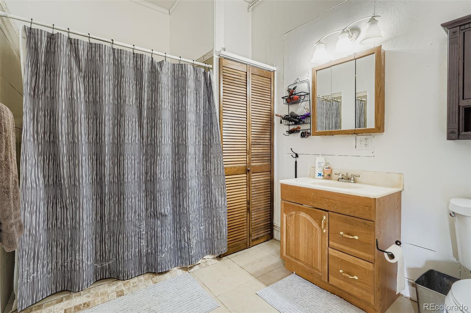 26540 Flower Circle Simla, CO 80835 - Photo 28 of 40 a bathroom with a sink a mirror and a shower curtain