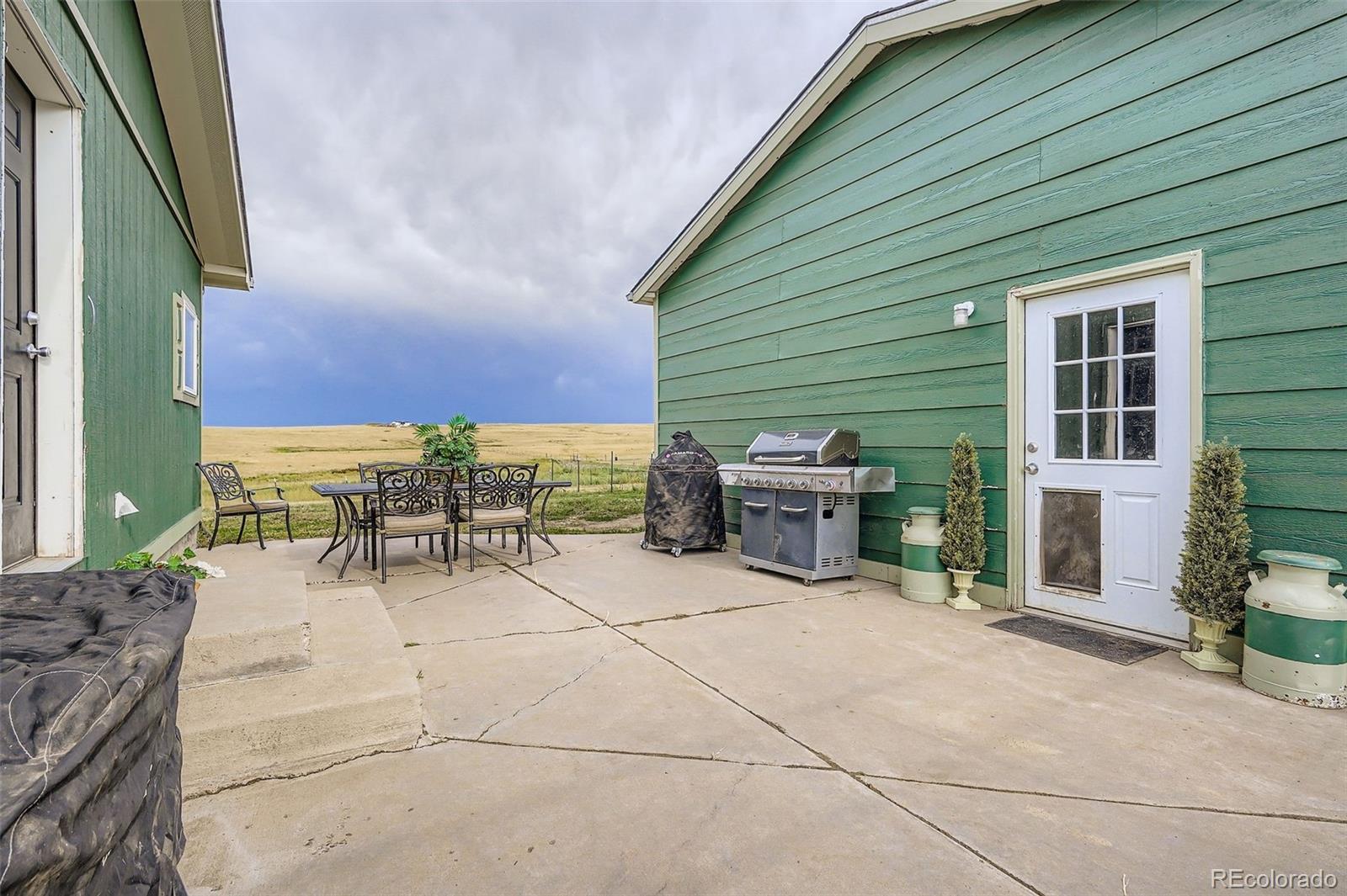 26540 Flower Circle Simla, CO 80835 - Photo 32 of 40 a view of a patio with table and chairs and a barbeque