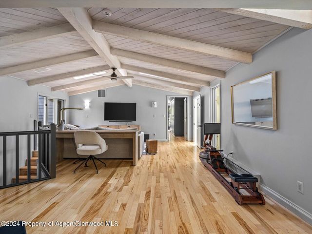 a living room with patio furniture and a flat screen tv
