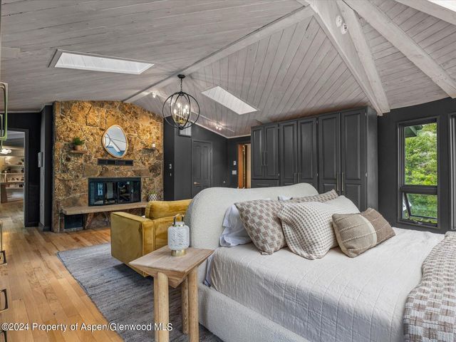 a bed sitting in a spacious bedroom next to a window