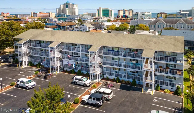 a living room with furniture kitchen view and a wooden floor