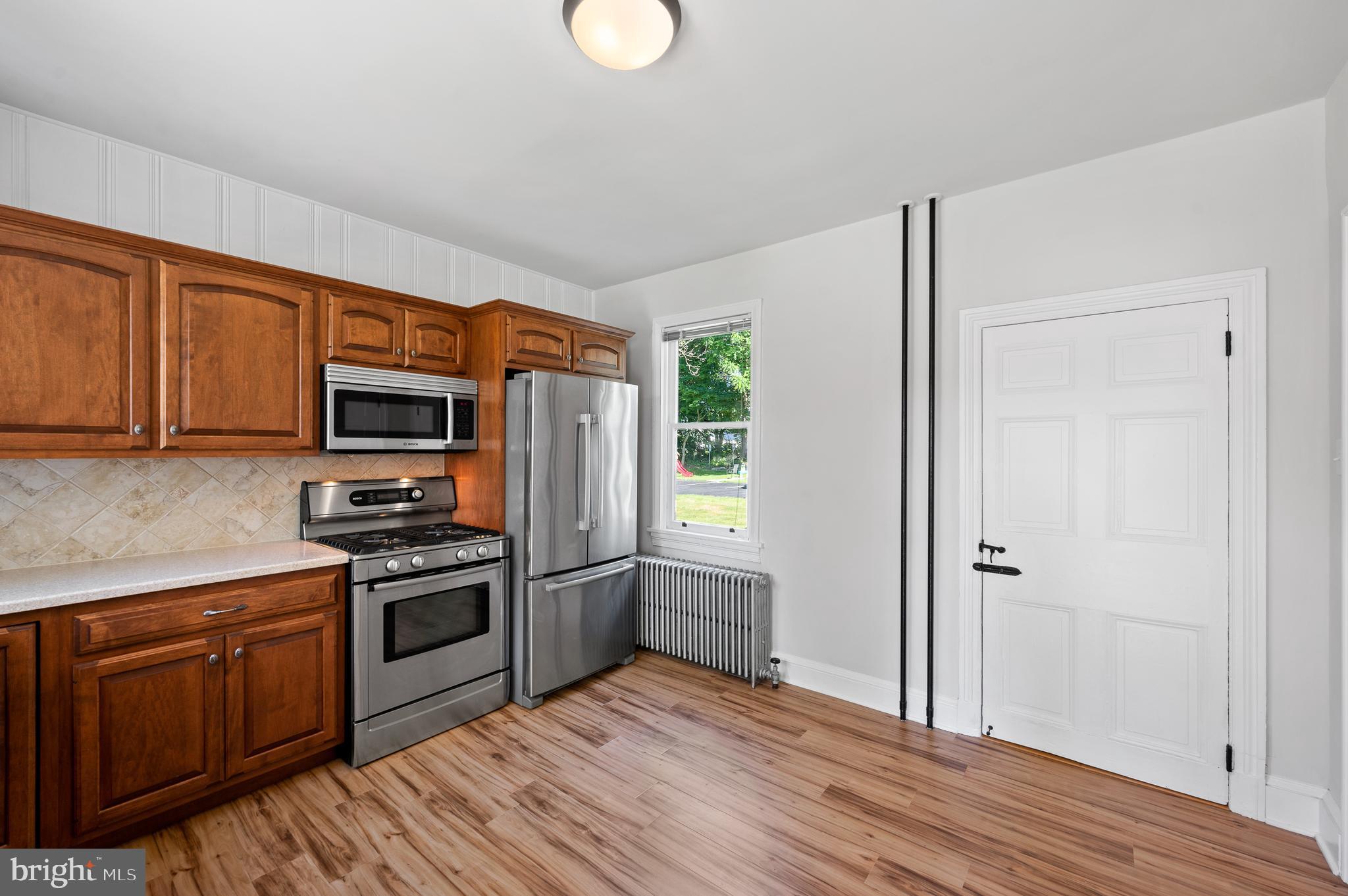 804 North Whitford Road Exton, PA 19341 - Photo 11 of 46 a kitchen with stainless steel appliances granite countertop a refrigerator stove top oven and sink with wooden floors