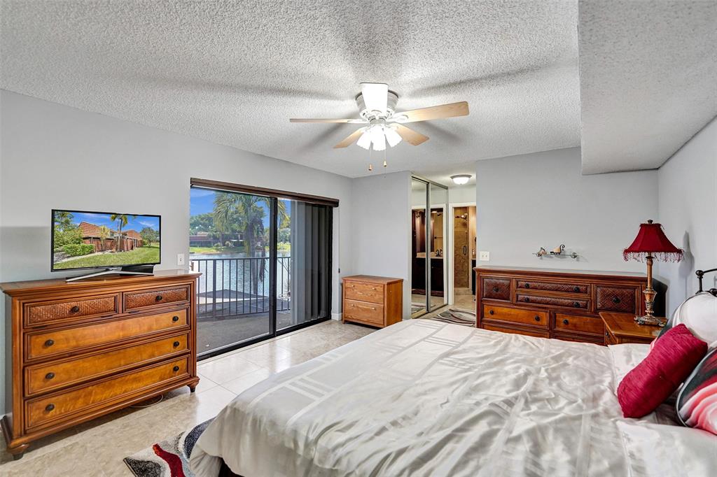 11884 Southwest 12th Place, Unit 11884 Davie, FL 33325 - Photo 31 of 48 a bedroom with a bed and wooden floor
