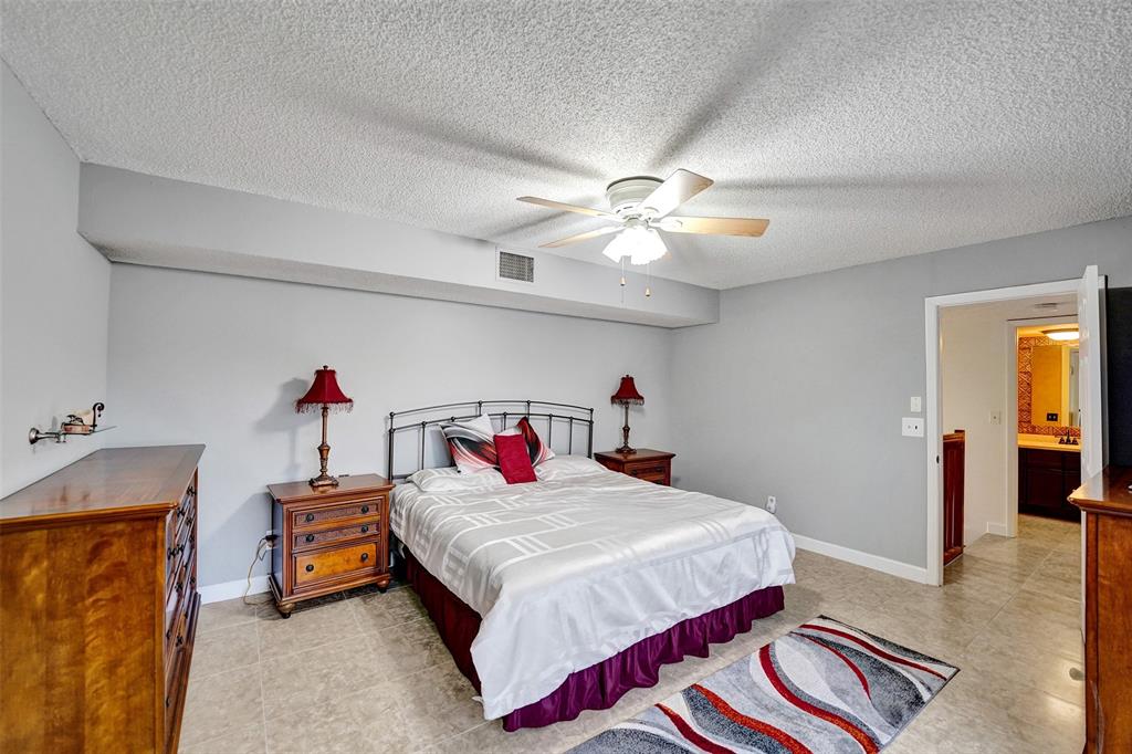 11884 Southwest 12th Place, Unit 11884 Davie, FL 33325 - Photo 32 of 48 a bedroom with a bed and a chandelier