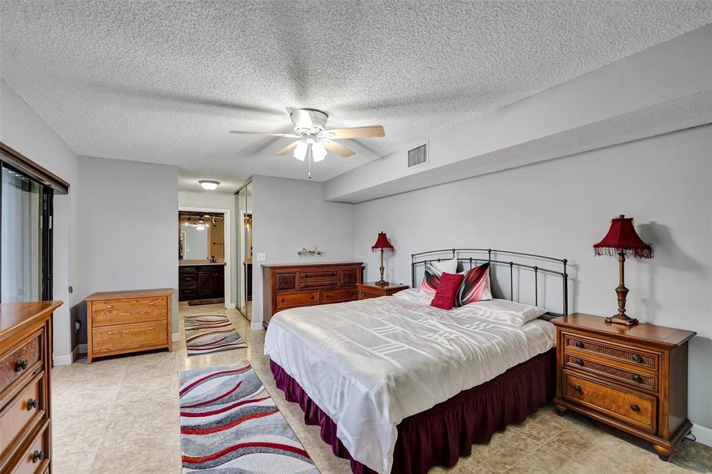 11884 Southwest 12th Place, Unit 11884 Davie, FL 33325 - Photo 33 of 48 a bedroom with double bed and a chandelier