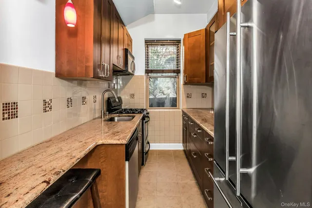 a kitchen with stainless steel appliances granite countertop a refrigerator and a sink